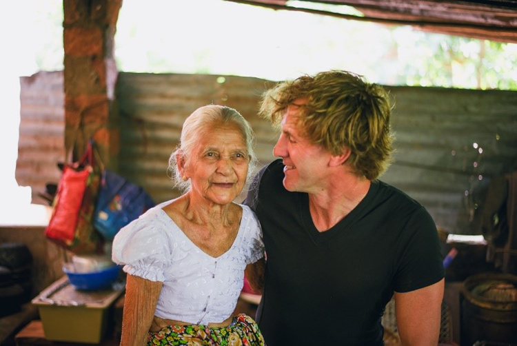 Travel Blogger posing for a picture with a local grandmother and tasting her cooking